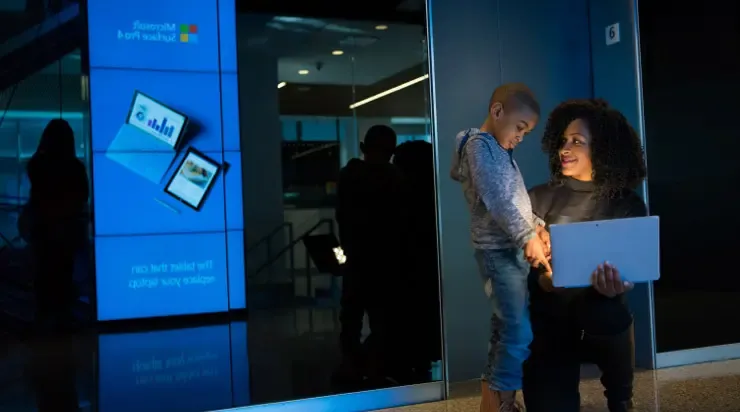 Woman and child looking at a tablet in a technology store
